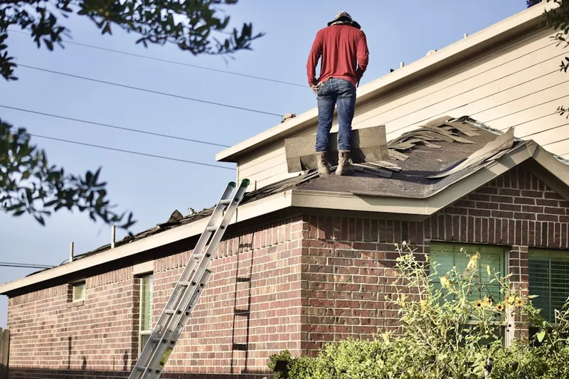 Professional roofer working on a residential roof in Godfrey